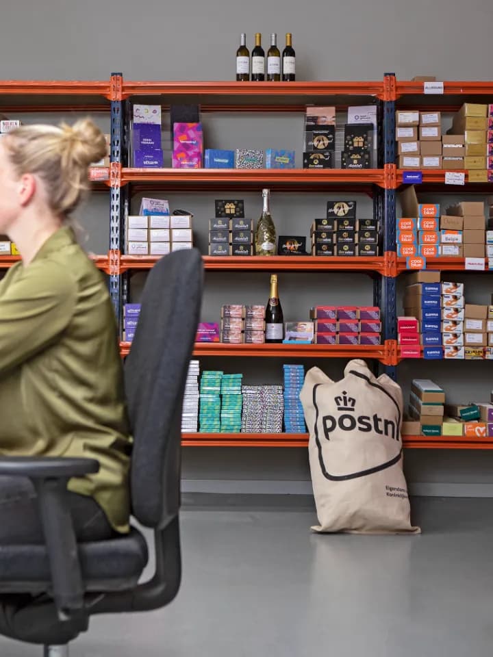 Collega bij de kast met cadeaukaarten die klaarstaan voor verzending