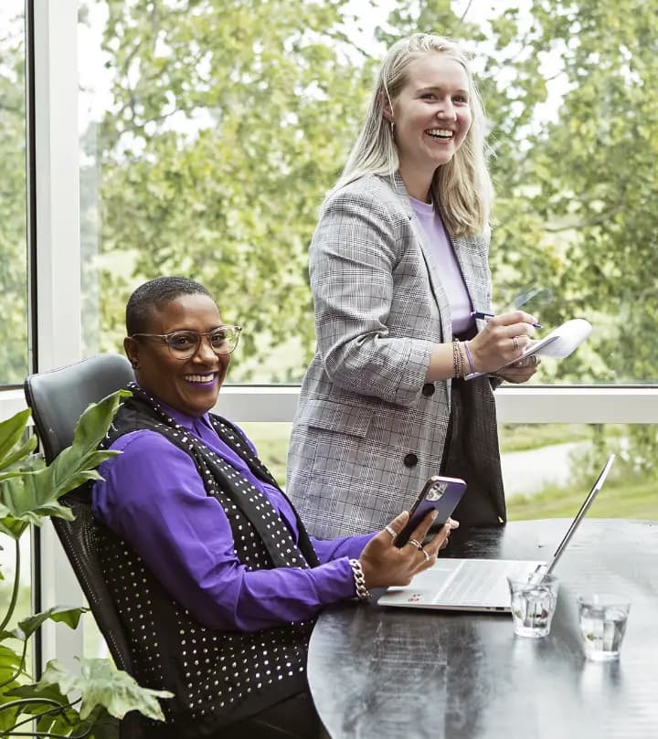 Twee collega’s lachen tijdens een overleg